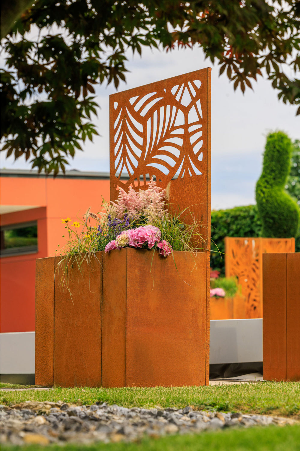 Hochbeet Monterosso mit Sichtschutz Motiv Piave bepflanzt mit bunten Blumen im Sommer | Cortenstahl Hochbeet Monterosso mit Sichtschutz Motiv Piave bepflanzt mit bunten Blumen im Sommer | Cortenstahl