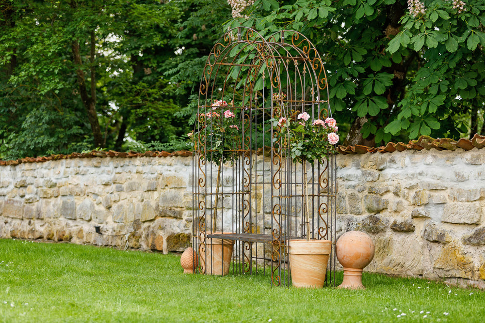 Rosenbogen Calabria mit Bank und Rückwand in Rostoptik Gesamtansicht mit Rosen und Dekoration Rosenbogen Calabria mit Bank und Rückwand in Rostoptik Gesamtansicht mit Rosen und Dekoration