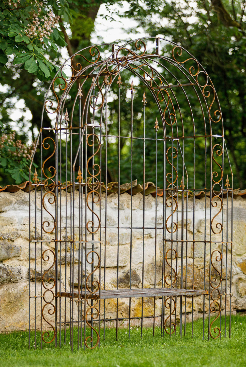Rosenbogen Calabria mit Bank und Rückwand in Rostoptik Gesamtansicht seitlich vor halbhoher Mauer Rosenbogen Calabria mit Bank und Rückwand in Rostoptik Gesamtansicht seitlich vor halbhoher Mauer