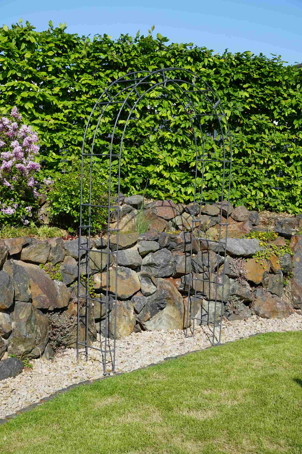 Rosenbogen Cremona anthrazit mit Blumendeko vor Steinmauer